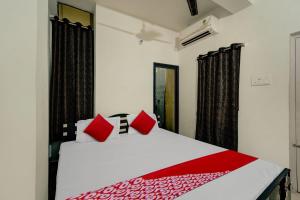 巴特那OYO Flagship Residence Inn Guest House的卧室配有带红色枕头的白色床