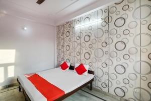 古尔冈OYO Flagship Corporate House的一间卧室配有一张带红色枕头的床