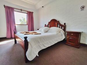 塔菲德尔瓦勒Hotel Los Cuartos的一间卧室配有一张带木制床头板的床和窗户。