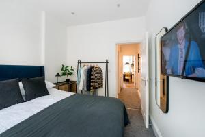 普雷斯顿Preston Apartments的一间卧室配有一张床和一台平面电视