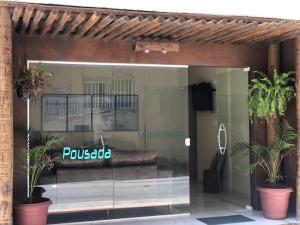 马拉戈日Fabika Pousada的玻璃库前,窗户上配有沙发