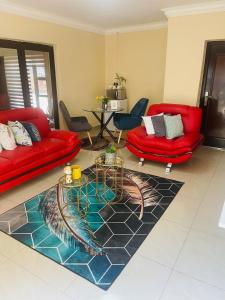 帕拉博鲁瓦Kalaji C-Rane Lodge的客厅配有两张红色的沙发和地毯。