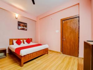博帕尔Hotel Crown Square的一间卧室配有一张带红色枕头的床和一扇门
