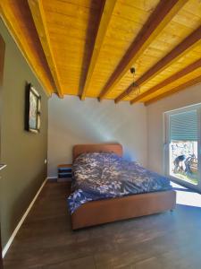 佩奇Villa Pax的一间卧室设有一张床和木制天花板