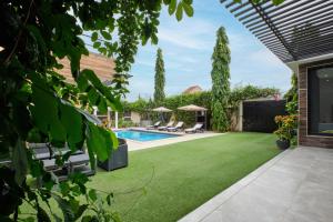 恩加帕鲁Villa Umy的后院设有绿色草坪和游泳池