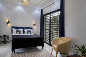 恩加帕鲁Villa Umy的卧室配有床、椅子和窗户。