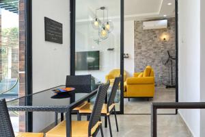 恩加帕鲁Villa Umy的用餐室配有桌椅和黄色椅子
