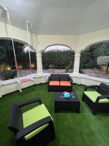 十月六日城Villa With A Private Garden In Beverly Hills的客厅配有沙发和桌子,位于草地上