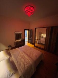 十月六日城Villa With A Private Garden In Beverly Hills的一间卧室配有一张大床和红色吊灯。