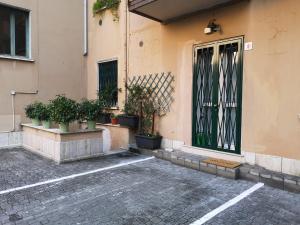 布雷西亚Holiday Apartment - Brescia centro - PARCHEGGIO PRIVATO的前面有盆栽植物的建筑的门