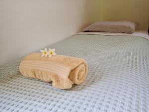 博卡斯德尔托罗Casa Salvaje Vacation Rentals的床上有毛巾和鲜花