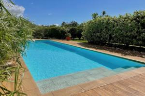 帕皮提Kaili Ocean view luxury 2BR AC throughout Fiber Wifi & Pool的庭院里的一个蓝色海水游泳池