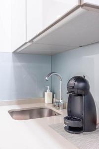 塞维利亚鲁本斯套房公寓的水槽旁的柜台上的一个咖啡壶