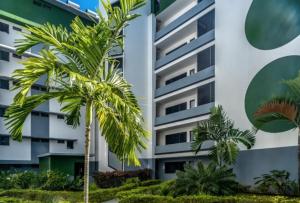 帕皮提Kaili Ocean view luxury 2BR AC throughout Fiber Wifi & Pool的一座棕榈树建筑