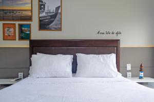 萨尔瓦多Apartamento Aconchegante Beira-Mar Ondina的一间卧室配有带白色床单和枕头的床。