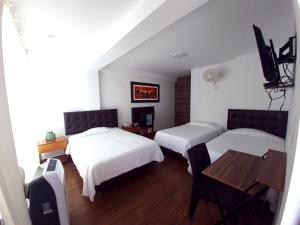 帕拉卡斯Hotel Golf Paracas的酒店客房设有两张床和一张桌子。