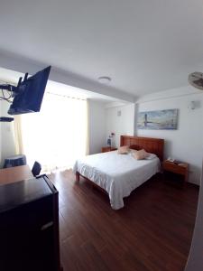 帕拉卡斯Hotel Golf Paracas的一间卧室配有一张床和一台平面电视