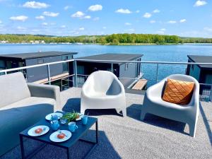MiddelaarLuxury houseboat with roof terrace and beautiful view over the Mookerplas的阳台配有两把椅子和一张船上沙发
