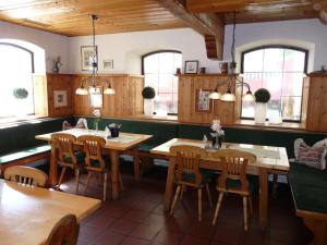 巴特比恩巴赫Rottaler Stuben的餐厅设有木桌、椅子和窗户。