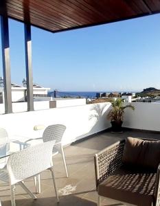 弗利康弗拉克3bed villa with private pool and rooftop with a sea view in flic-en-flac, Mauritius的一个带椅子和沙发的庭院,享有海景