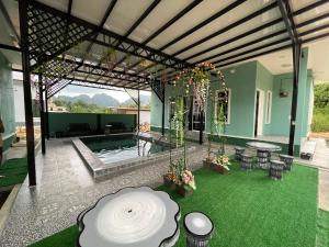 淡文Teratak Sakinah Guest House的一座带游泳池和绿草庭院的房子