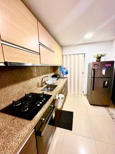 伊瓦格Apartamento completo的厨房配有炉灶和冰箱。