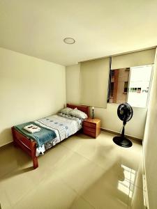 伊瓦格Apartamento completo的一间卧室配有一张床和一个风扇