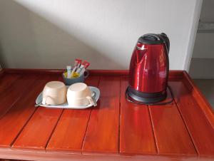 象岛Tropical Paradise Leelawadee Resort的红色咖啡壶和桌子上的两个杯子