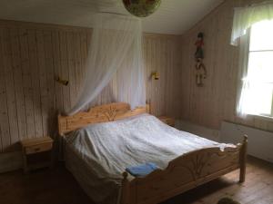 Sågen萨根车站旅馆的一间卧室配有一张木床和天篷