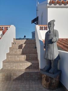 米尔芳提斯城Lar Dos Guerreiros的一座带楼梯的建筑一侧的雕像