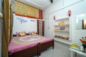 克久拉霍克久拉霍民宿的一间卧室配有一张带粉红色床罩的床