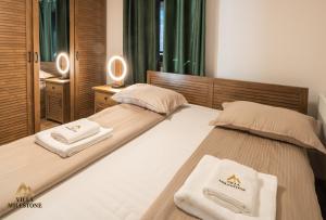 Villa Milestone Majevica的客房内的两张床和两条毛巾