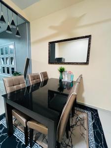 居銮Khalish homestay的一张黑色餐桌,配有椅子和镜子