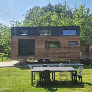 珀套特科姆博特Mini maison Tiny house 6 per 3800m2 jardin Jacuzzi的房屋前方设有桌椅