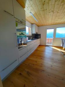 纳特斯Chalet Matterhornsicht的一间铺有木地板的大厨房,配有白色的橱柜