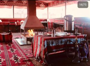 瓦迪拉姆Bedouin Memories Camp的一间设有桌子和壁炉的客房