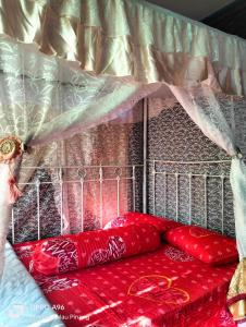 甲抛峇底Homestay Teratak Kayu kota Aur的床上有红色枕头的床