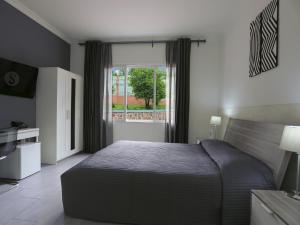 基加利5瑞士酒店的一间卧室设有一张大床和一个窗户。