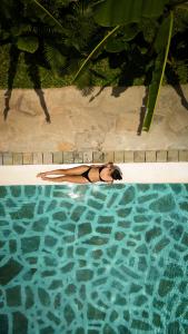 瓦塔穆Rafiki Tamu Residential Resort的女人躺在游泳池里
