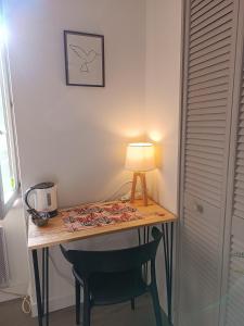曼特埃尔Elise cornu的一张桌子,里面配有一盏灯和一把椅子