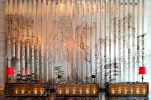 青岛青岛富力艾美酒店的一间有一面墙的房间,里面有树木的雕塑