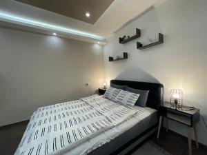 BečejApartman Central A&D的一间卧室配有一张白色的床和黑色床头板