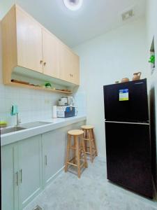 甲万那端6 - Affordable 2-Storey House in Cabanatuan City的厨房配有黑色冰箱和水槽