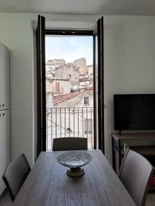 圣安吉罗山Casa Junno的一间带桌子和大窗户的用餐室
