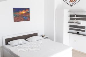 马马亚RoApart Mamaia - Riva Lake Apartments的卧室配有一张白色的床,上面有篮子