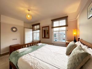 伦敦Daisy’s Place in London的一间卧室设有一张大床和两个窗户。