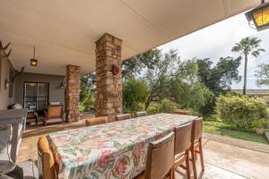 阿马卡拉保护区Tygerfontein Safari Villa的庭院设有一张桌子和椅子,庭院设有石柱