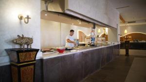 考拉亚湾Amarina Jannah Resort & Aqua Park的两个人在餐厅厨房准备食物