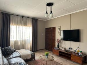 卢萨卡Serene 3 bedroom house in Olympia, Lusaka的带沙发和平面电视的客厅