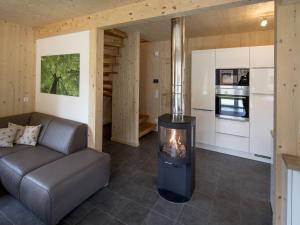 穆劳附近圣洛伦岑Wooden Chalet in Sankt Georgen ob Murau with Sauna的客厅设有壁炉和厨房。